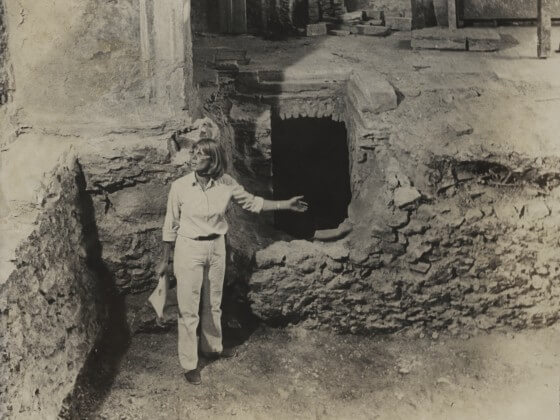 Frau steht in einer archäologischen Ausgrabungsgrube in der Karmeliterkirche